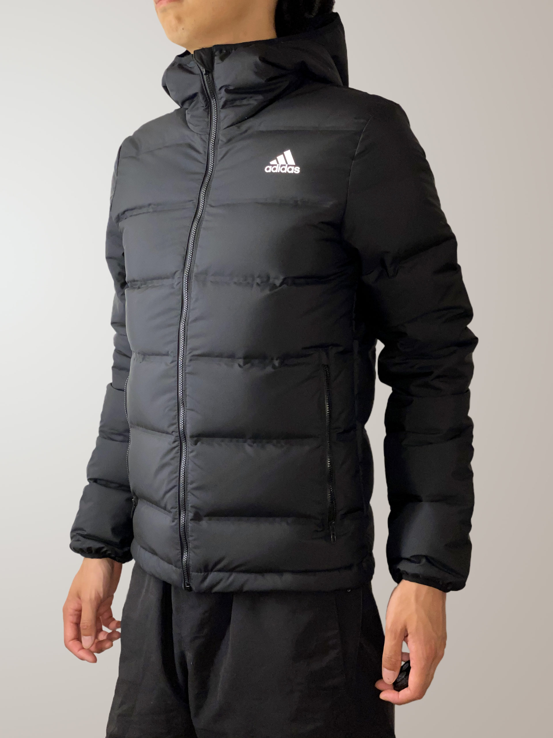 Чёрная куртка Adidas Helionic на человеке, вид спереди